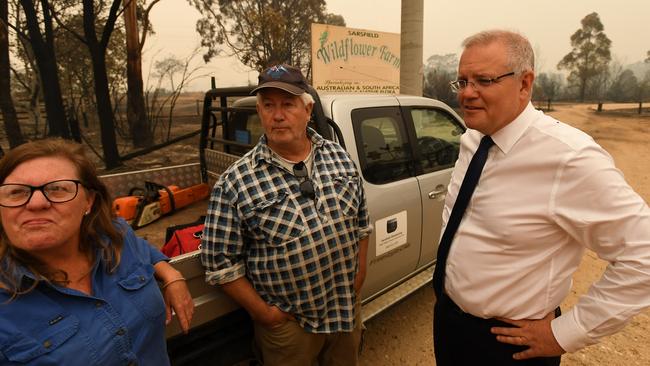 Melissa and Paul Churchman with Scott Morrison at their destroyed farm in Sarsfield, Victoria, on Friday. Picture: Getty Images