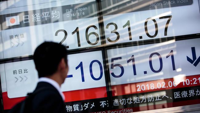 A man walks past a board at the Tokyo Stock Exchange. Picture: AFP