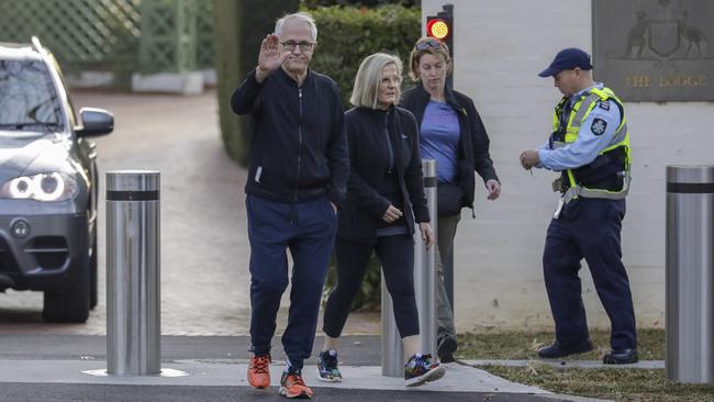 Malcolm Turnbull leaves The Lodge in Canberra with wife Lucy on his morning walk on Sunday and waves to the waiting media. Picture: Sean Davey