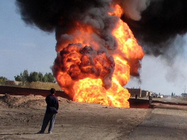 Iraqi youths watch a burning oil pipeline near Taji, north of Baghdad, Feb. 17, 2006. Insurgents blew up the main pipeline feeding crude oil from the northern oil fields of /Kirkuk to a refinery in the suburb of /Dora and stopping the flow of oil. (AP PicAhmed/Al/Dulimi) fires o/seas Iraq insurgency flames burning terrorism smoke