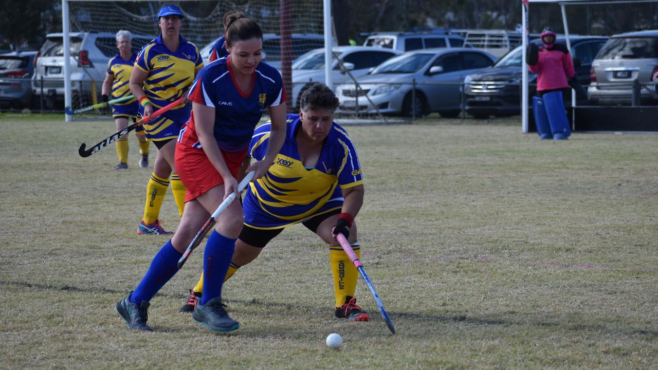 Danielle Cook (Warwick) and Lew Urquhart (Townsville) fight for possession in the big clash at the 2021 Queensland Hockey Women's Masters Championships.