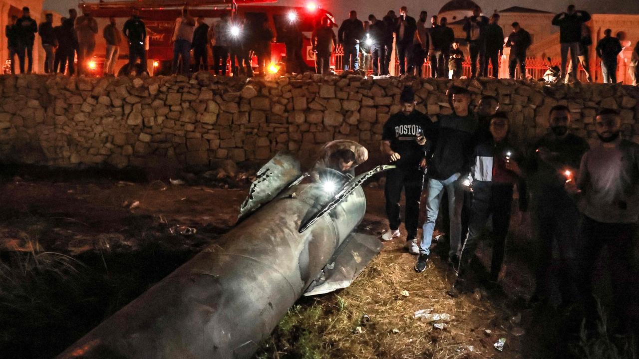 Palestinian youths inspect a fallen projectile after Iran launched a barrage of missiles at Israel in response to the killings of Lebanese Hezbollah leader Nasrallah and other Iran-backed militants, in Ramallah in the occupied West Bank on October 1. Picture: Zain Jr / AFP