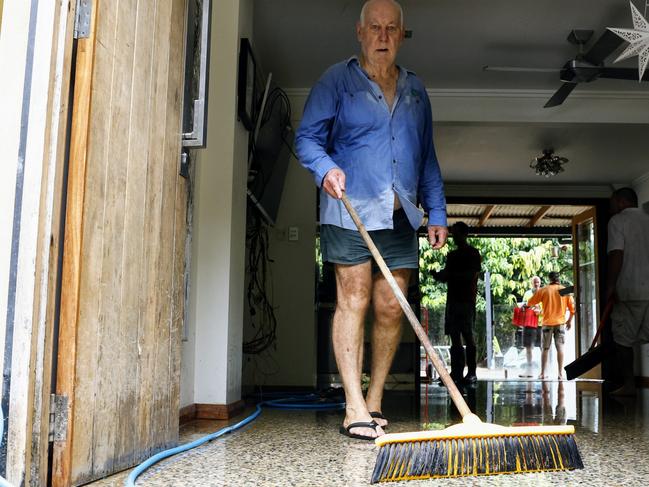 Eddie Wickham sweeps water out of a house in Cairns following extreme flooding. Picture: Brendan Radke