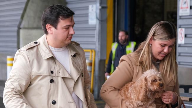 Brittany Higgins and David Sharaz cuddle their cavapoodle dog Kingston and carry their cat Clover after the animals cleared quarantine at the Bordeaux-Merignac airport in France. Picture: Jacquelin Magnay