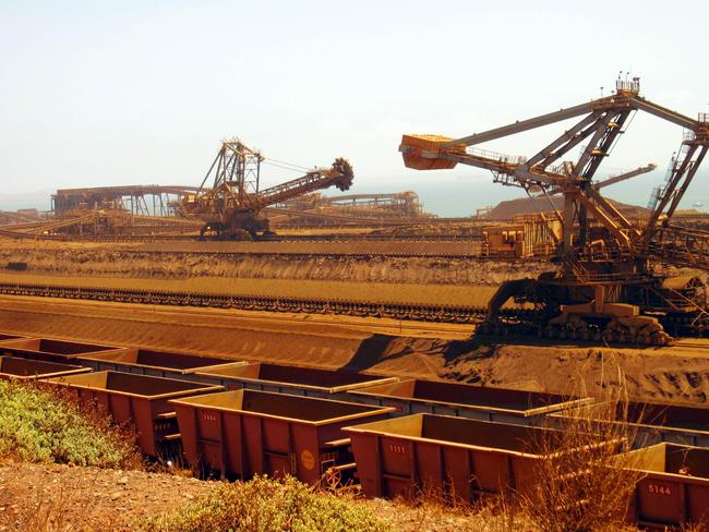 (FILES) This file photo taken on March 4, 2010 shows remote-controlled stackers and reclaimers moving iron ore to rail cars at Rio Tinto's Port Dampier operations in Western Australia's Pilbara region. - Rio Tinto's CEO and two other top officers resigned on September 11, 2020 after an uproar over the mining giant's destruction of an ancient Aboriginal heritage site to expand an iron ore mine in Australia. (Photo by Amy COOPES / AFP)