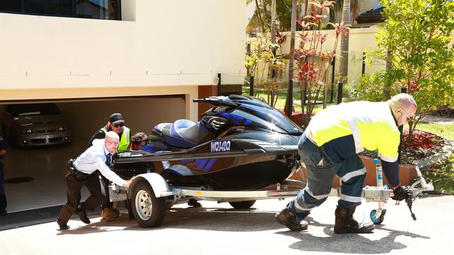 A police raid at Andrea Court, Broadbeach Waters resulted in 2 people being arrested, 2 cars, a jet ski and a motorbike being seized. Photo: Kit Wise