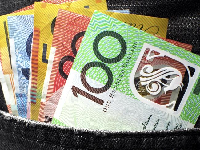 Australian money including 100, 50, 5, 10 and 20 dollar notes, in back pocket of a man's black charcoal jeans pocket. Vertical.