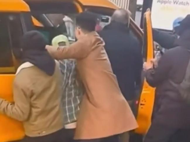 Australians among six hit when taxi veered into pedestrians in New York on Christmas Day. Members of the public try to free those hot. Picture: Nine