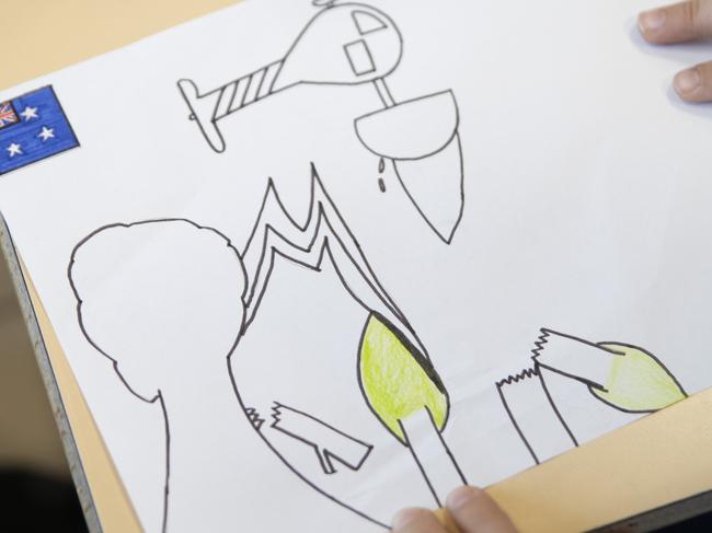 “Sorry for you but I hope it gets better,” is the message that Timeo, 9, said he would write on the back of his drawing, which featured a helicopter dropping water on blazing trees. Picture: Marie Genel