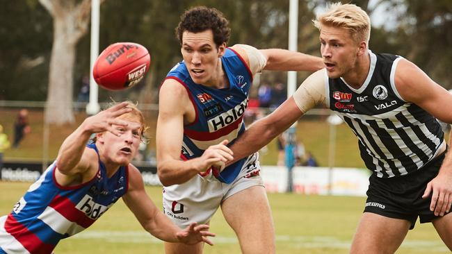 Darcy Fort (centre) looks to shepherd Billy Frampton away from the ball.