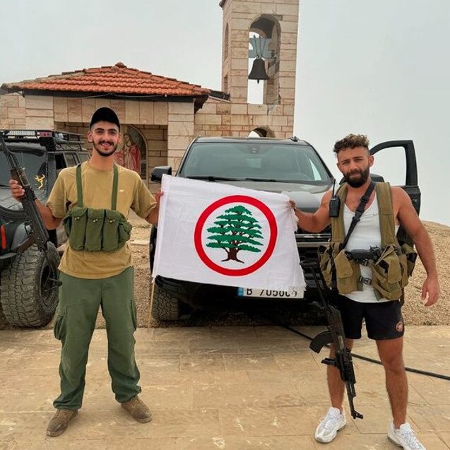 Jason Tarraf, right, poses in Lebanon holding an automatic weapon. Picture: Instagram