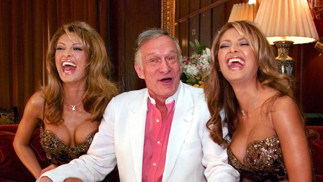 Hefner with Playmates Carol and Darlene Bernola in 1999.