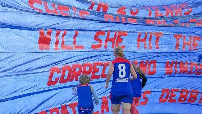 Debbie Lee runs through her banner for her 300th game.