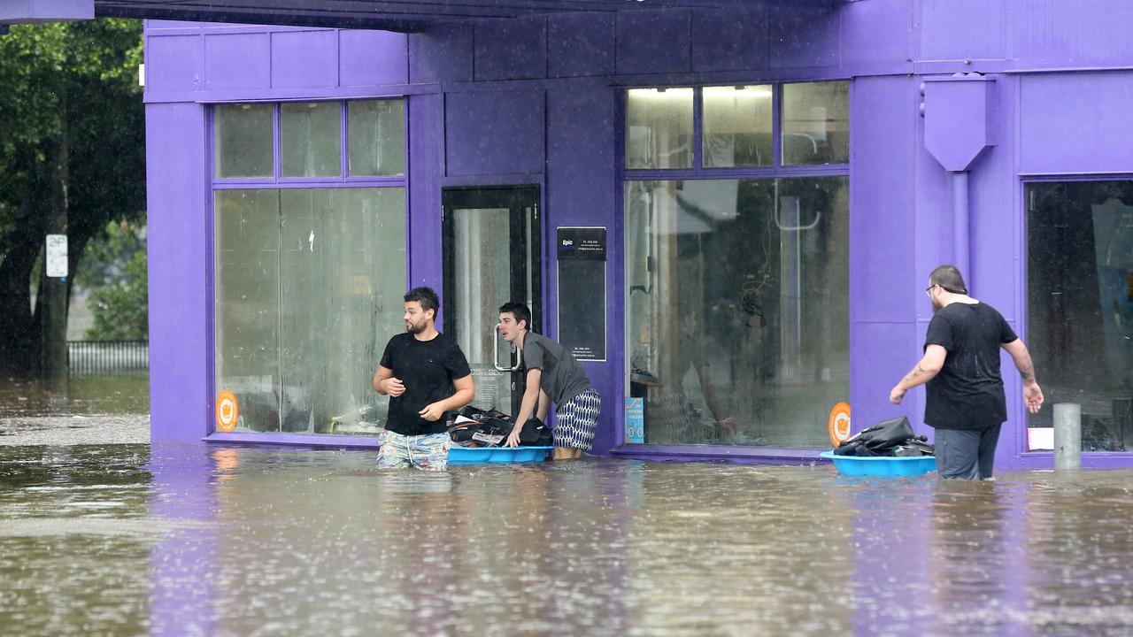 Staff try and save goods from a property on Baroona Rd, Milton. Picture: Steve Pohlner