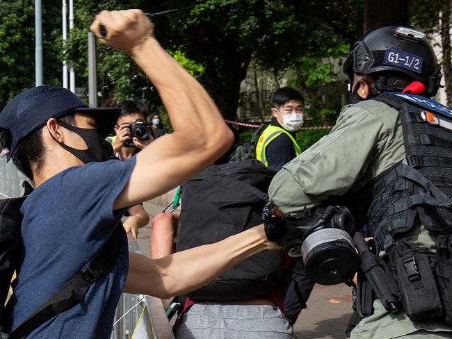 A protester attacks a police officer with a sharp object in Hong Kong. Picture: AFP