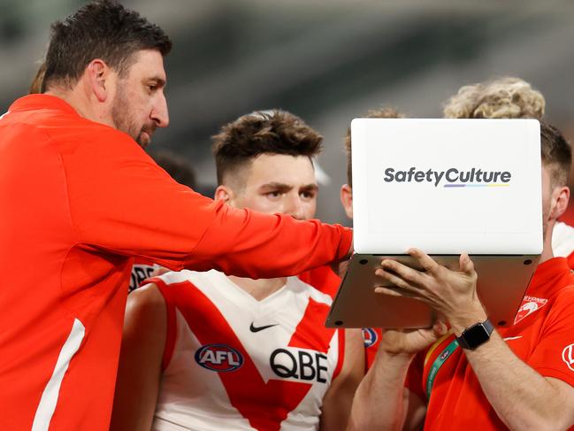 MELBOURNE, AUSTRALIA - JUNE 04: Dean Cox, Game Strategy & Ruck Coach of the Swans instructs players on a laptop during the 2022 AFL Round 12 match between the Melbourne Demons and the Sydney Swans at the Melbourne Cricket Ground on June 04, 2022 in Melbourne, Australia. (Photo by Michael Willson/AFL Photos via Getty Images)