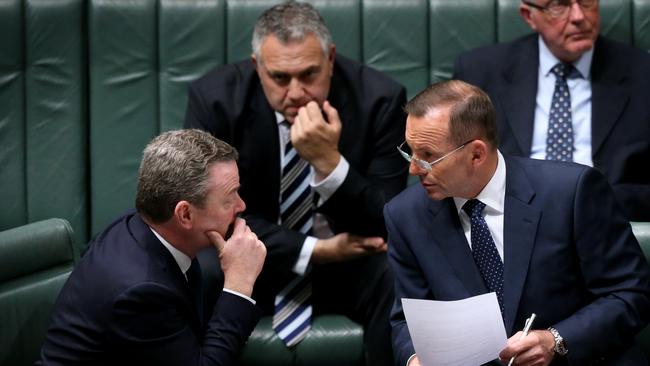 Manager of Government Business Christopher Pyne and Tony Abbott watched by Joe Hockey confer during Question Time.