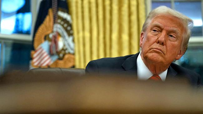 US President Donald Trump speaks looks on after signing an executive order in the Oval Office of the White House.