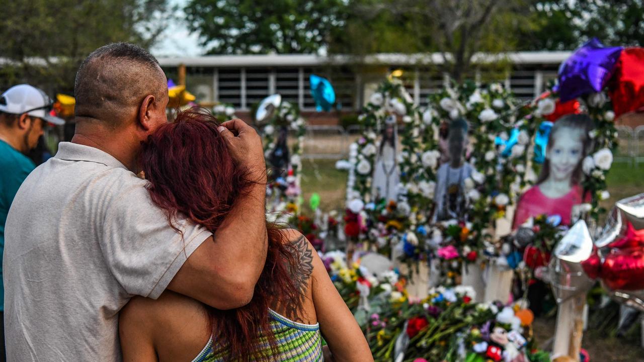 People pay tribute and mourn at a makeshift memorial for the victims of the Robb Elementary School shooting in Uvalde. Picture: Chandan Khanna/AFP