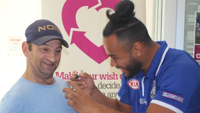 Canterbury Bulldogs player Christian Crichton signs the T-shirt for the club’s big fan Mark Galea.