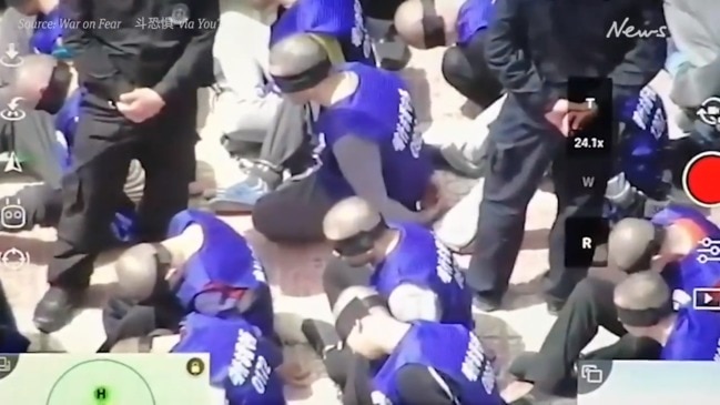 Chilling drone footage shows Chinese police transferring blindfolded and shackled prisoners