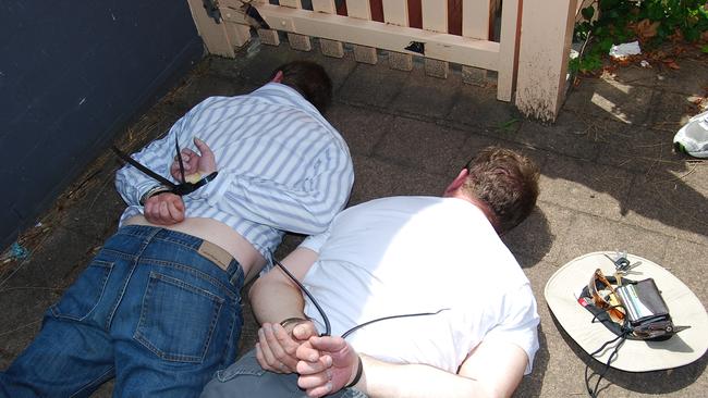 Anthony Perish (L) and Sean Waygood handcuffed on the ground a after raid by heavily-armed officers of Strike Force Tuno in 2001.