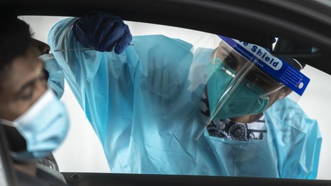 A health worker carries out a COVID-19 testing at the Merrylands drive-through clinic on in Sydney. Picture: Getty Images