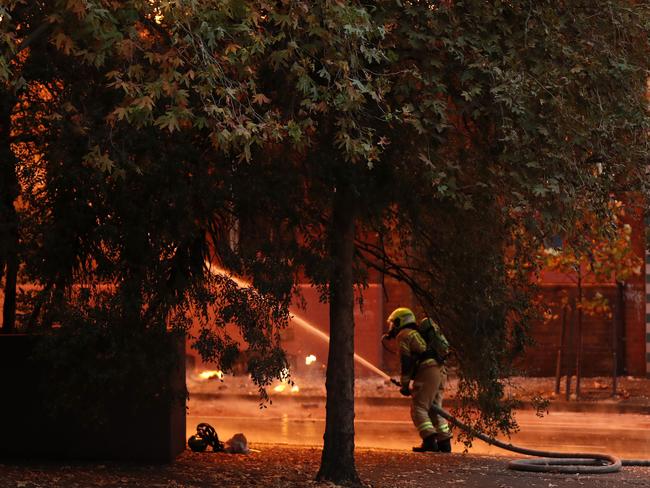 A firefighter battles the blaze, which is lighting up the street. Picture: Jonathan Ng