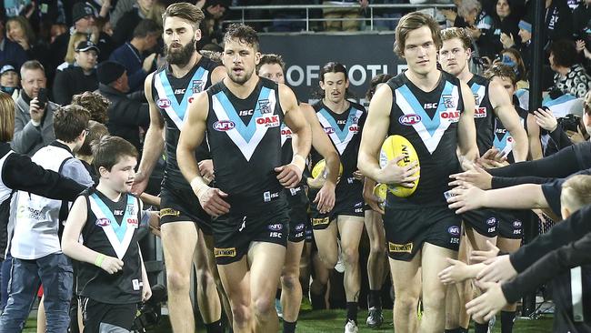 Travis Boak leads his team out onto the oval.