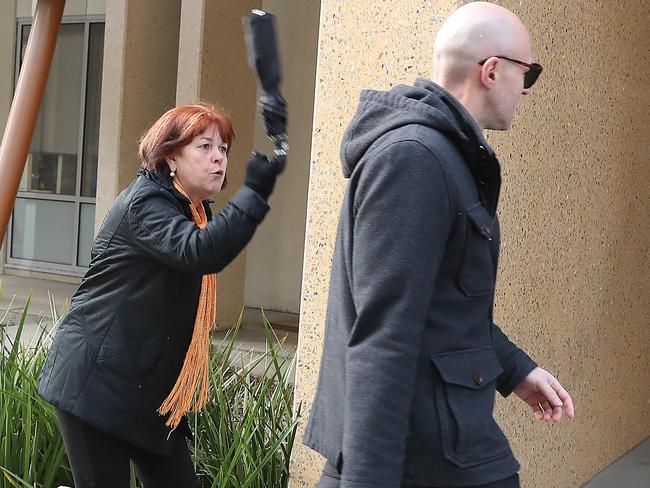 Snezana Stojanovska’s aunt waves her umbrella at Dragi Stojanovski outside the Coroner’s Court. Picture: Alex Coppel