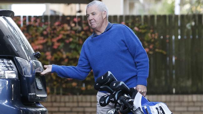 Mike Tancred leaves his Mosman apartment for the golf course on Saturday.