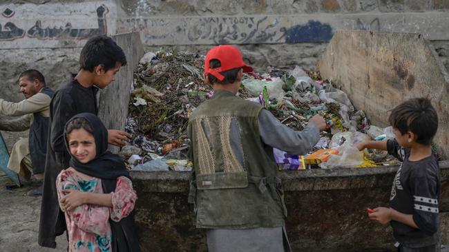 Children collect food and recyclable materials through garbage near the airport in Kabul. Picture: AFP