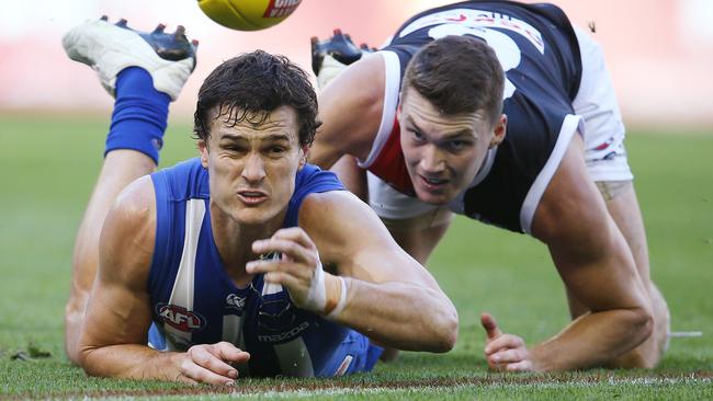 Scott Thompson gets a handball away under pressure from Blake Acres. Picture: Michael Klein