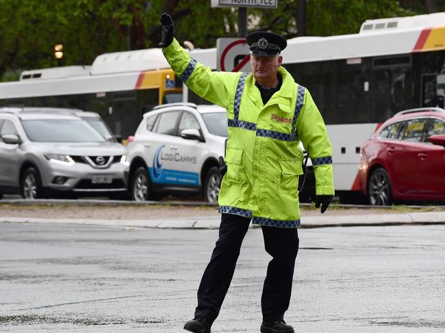 Sen-Constable Brian Strathearn directs traffic on North Tce and King William St. Picture: Campbell Brodie