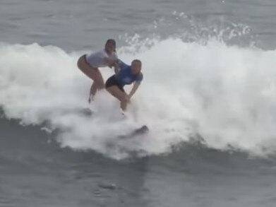 A Portugal surfer (left) tries to push Aussie girl Willoy Hardy (right) off her board.