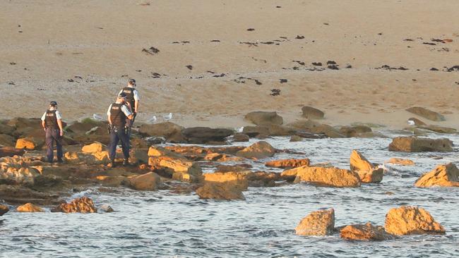 Police scour the shore for human remains. Picture: John Grainger