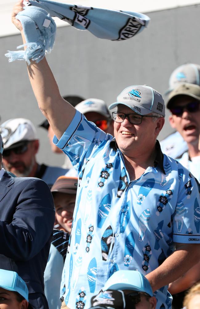 Prime Minister Scott Morrison gets into the spirit of the game watching his team the Cronulla Sharks against Canberra Raiders. Picture: Jonathan Ng