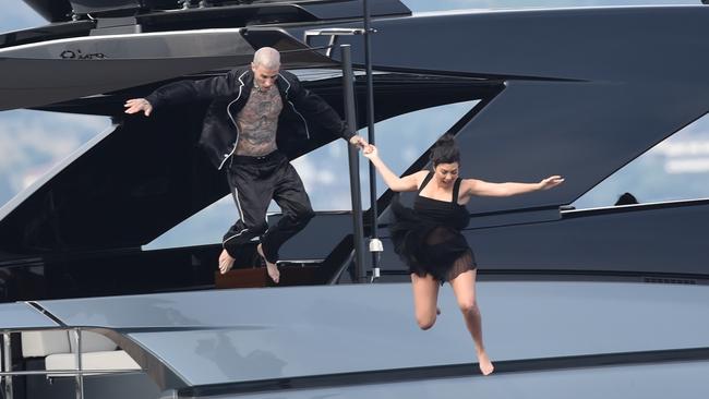 Kourtney Kardashian and Travis Barker held hands jumping from a yacht after their wedding. Picture: Cobra Team / BACKGRID