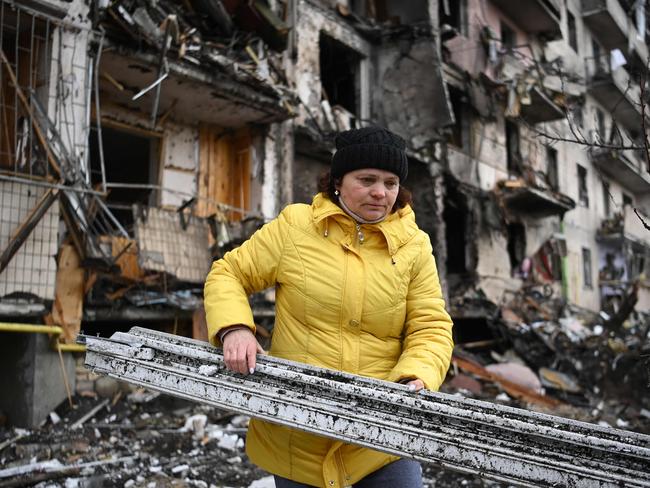 A woman clears debris at a damaged residential building at Koshytsa Street, a suburb of the Ukrainian capital Kyiv. Picture: Daniel Leal/AFP)