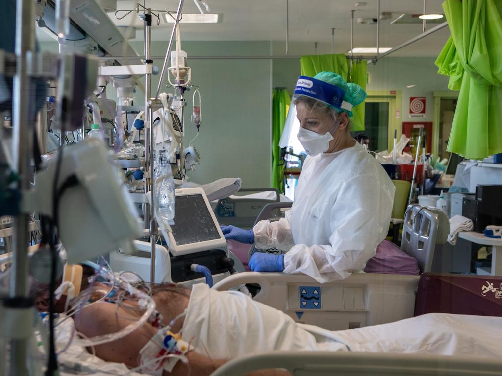 Doctor Annalisa Malara, wearing Personal Protective Equipment, stands next to a patient in the Covid-19 Intensive Care Unit of the Ospedale Maggiore di Lodi, near Milan, Italy where virus cases are “explosive”. Picture: Emanuele Cremaschi/Getty Images