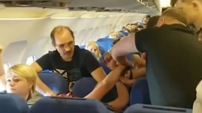 Passenger on board a flight appears drunk and covered in blood in video posted to Youtube. Picture: Youtube