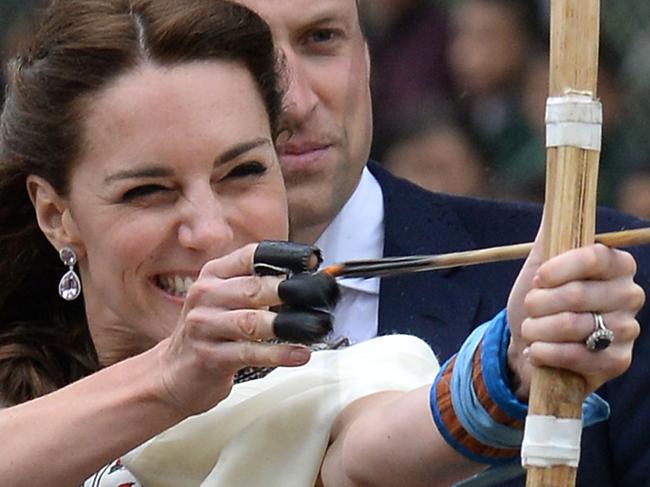 Kate Duchess of Cambridge takes part in an archery event as her husband Prince William looks over her shoulder in Thimphu, Bhutan, during day five of the royal tour to India and Bhutan Thursday April 14, 2016. (Joe Giddens/PA via AP) UNITED KINGDOM OUT NO SALES NO ARCHIVE