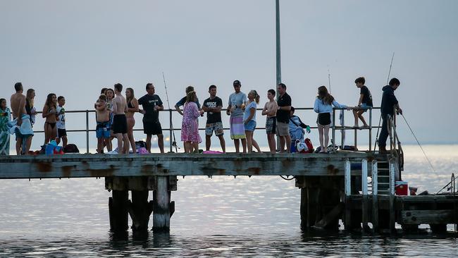 Clusters of adults and kids gather on the pier at Half Moon Bay in Black Rock not adhering to coronavirus social distancing. Picture: Ian Currie