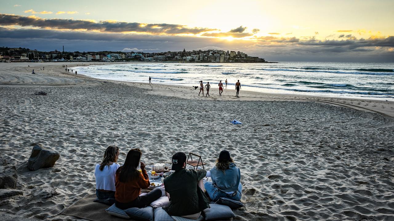 People having picnics on Monday as double vaccinated residents are allowed to gather in five or more outdoors at Bondi Beach in Sydney. It’s a different story across the rest of the world though. Picture: NCA NewsWire / Flavio Brancaleone