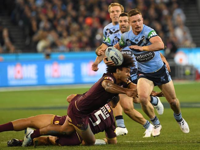 Damien Cook (R) breaks a tackle of Felise Kaufusi. Pic: AAP