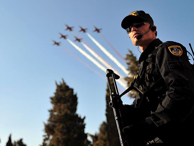 A nation celebrates ... the Turkish Stars aerobatic team fly their Northrop F-5 Freedom Fighters as a Turkish special force soldier stand guard in Canakkale. Picture: AFP PHOTO/OZAN KOSE