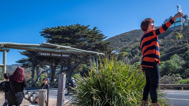 Tourists take photos at the Memorial Arch. Picture: Jake Nowakowski