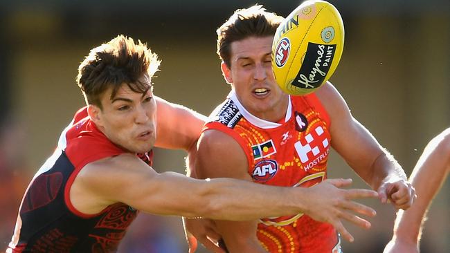 Gold Coast midfielder David Swallow handballs under pressure from Jack Viney. Picture: Getty Images