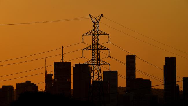 A high voltage electricity transmission tower is seen in the foreground of the Brisbane CBD skyline in Brisbane, Tuesday, January 15, 2019. AAP Image/Darren England) NO ARCHIVING