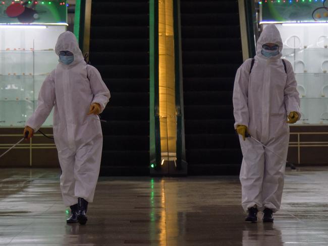 (FILES) In this file photo taken on December 28, 2020 health workers spray disinfectant inside the Pyongyang Department Store No. 1 prior to opening for business, in Pyongyang on December 28, 2020. - North Korea on May 12, 2022 confirmed its first-ever case of Covid-19, with state media declaring it a "severe national emergency incident" after more than two years of purportedly keeping the pandemic at bay. (Photo by KIM Won Jin / AFP)